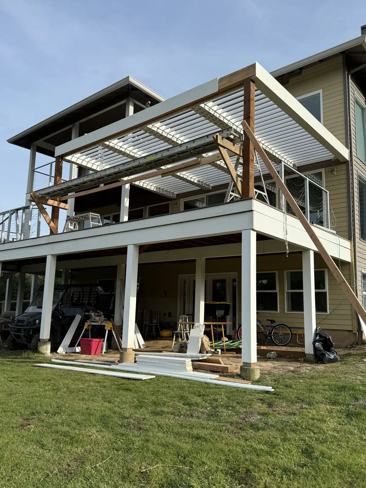 Roof framing going up over an elevated deck with cable railing on a Portland home