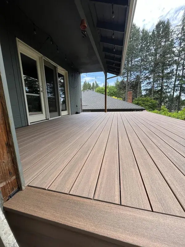 The same deck finished, a new brown surface laid across the frame that was kept, running up to the doors