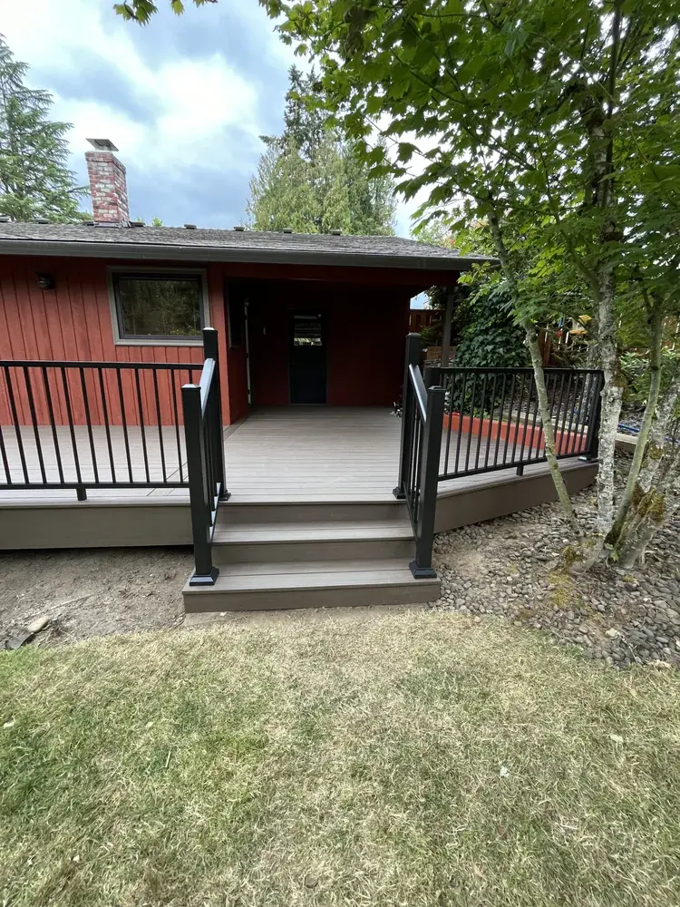 PVC steps with black aluminum railing rising from the lawn to a deck and its landing
