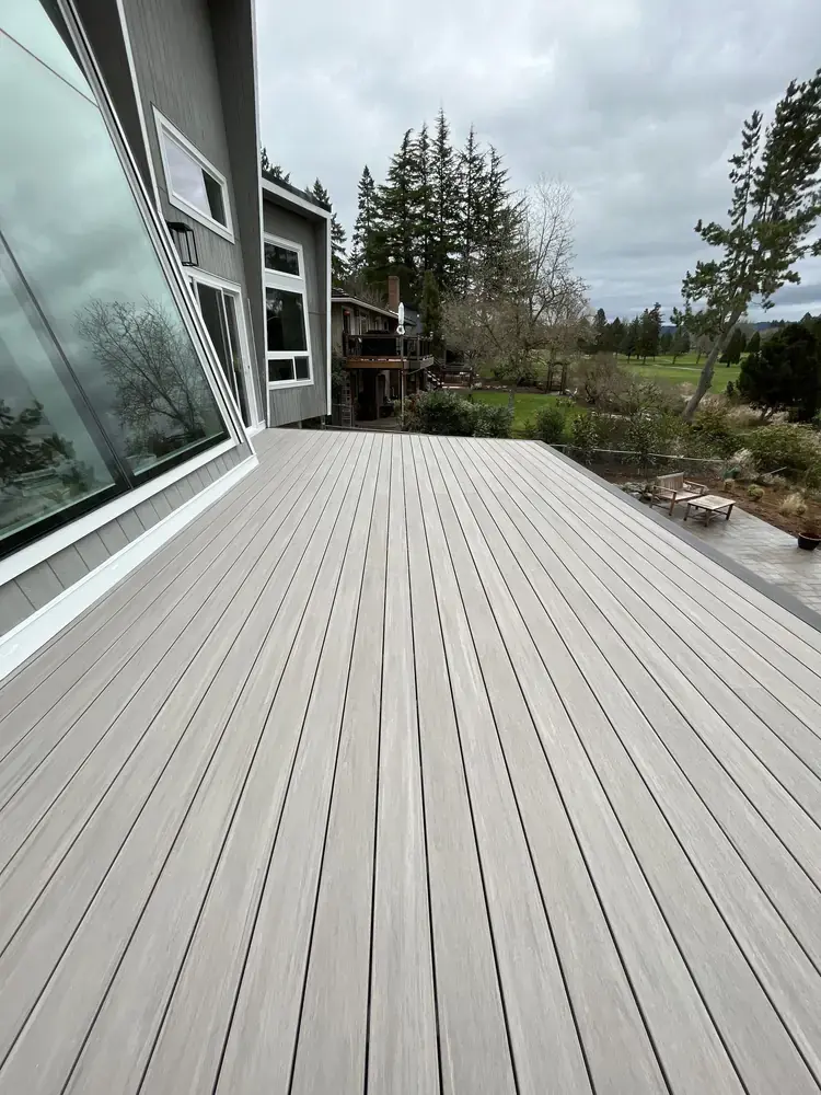 Wide greige PVC deck running the length of the house, looking out over a golf course fairway